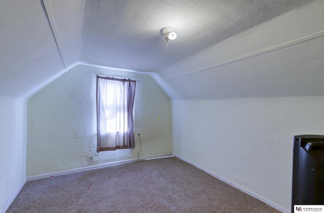 additional living space with vaulted ceiling and carpet