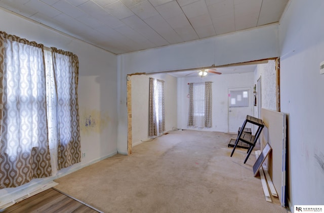 unfurnished room featuring ceiling fan, light colored carpet, and a healthy amount of sunlight