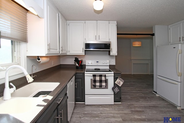 kitchen featuring white appliances, a textured ceiling, and white cabinets