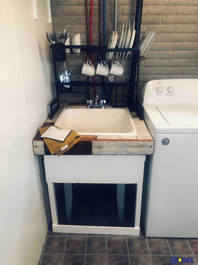 clothes washing area with washer / dryer and sink