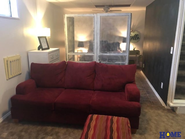 living room featuring ceiling fan and dark carpet