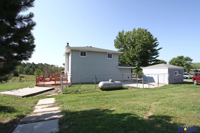 rear view of property featuring a shed, a yard, and a deck