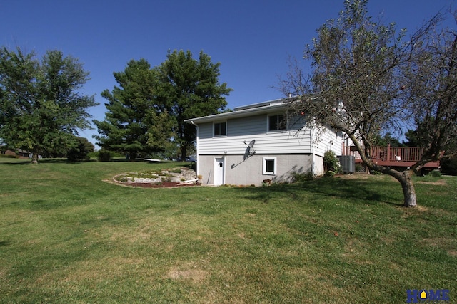 rear view of house featuring a wooden deck, central AC unit, and a lawn