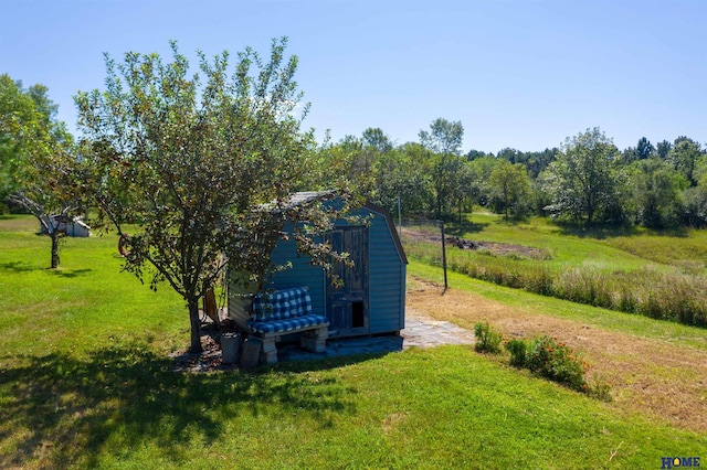 view of property's community with a storage shed, a rural view, and a lawn