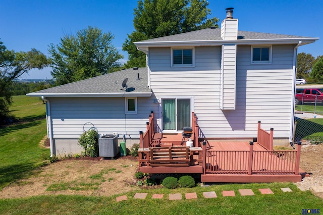 rear view of house featuring central AC, a wooden deck, and a lawn