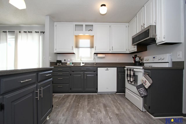 kitchen featuring white cabinetry, white appliances, sink, and a textured ceiling