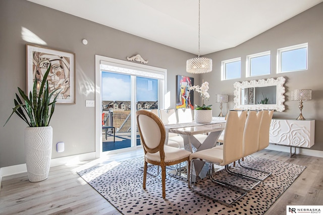 dining area featuring hardwood / wood-style flooring and vaulted ceiling