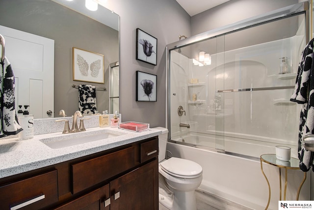 full bathroom with vanity, shower / bath combination with glass door, and toilet