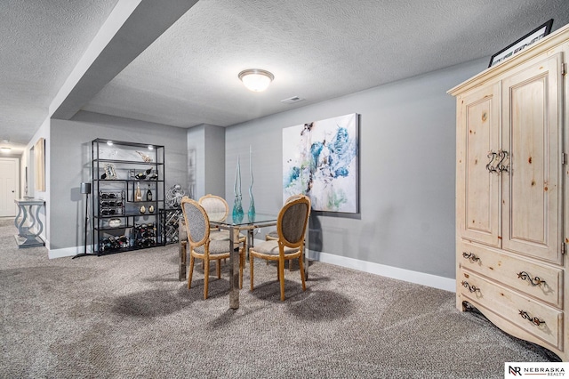 dining space with carpet flooring and a textured ceiling