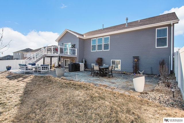 rear view of house featuring a wooden deck, a yard, and a patio