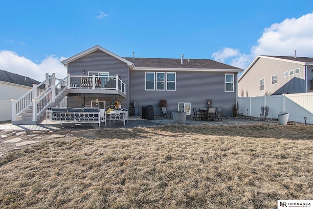 rear view of house with a deck, central air condition unit, a patio, and a lawn