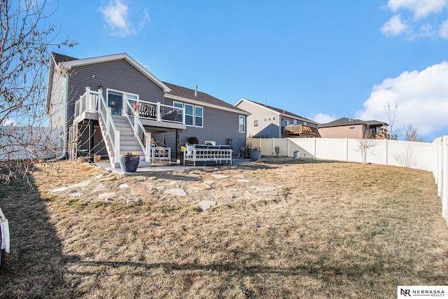 back of house featuring a lawn, a patio, and a deck