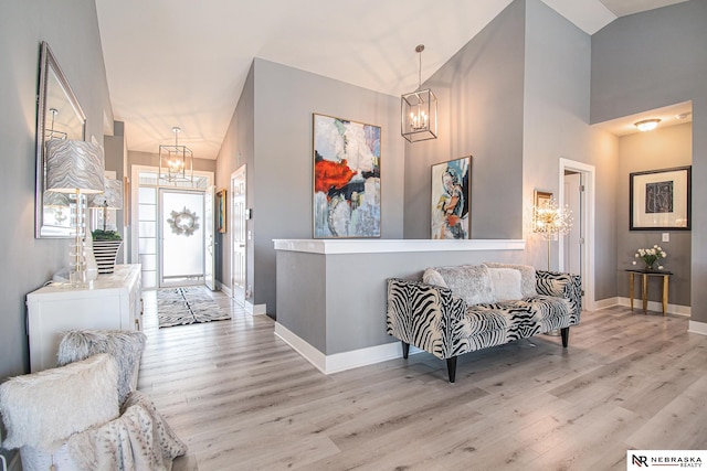 entrance foyer with light hardwood / wood-style flooring, a chandelier, and vaulted ceiling