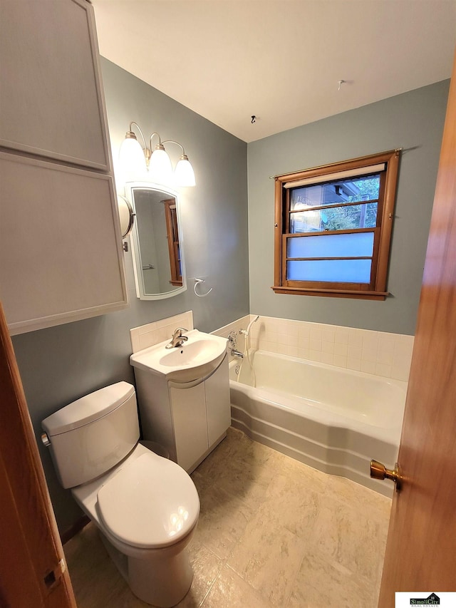 bathroom with vanity, a tub, and toilet