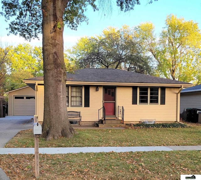 single story home featuring a garage, an outdoor structure, and a front yard