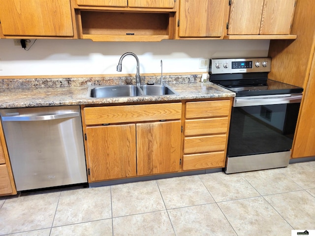 kitchen with sink, light tile patterned flooring, and appliances with stainless steel finishes