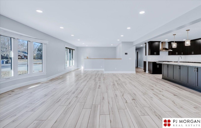 unfurnished living room with sink and light hardwood / wood-style flooring