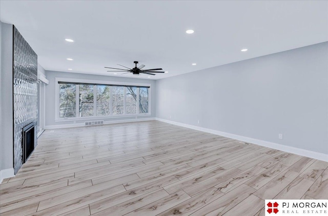 unfurnished living room with ceiling fan and light wood-type flooring