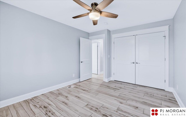 unfurnished bedroom featuring ceiling fan, a closet, and light wood-type flooring