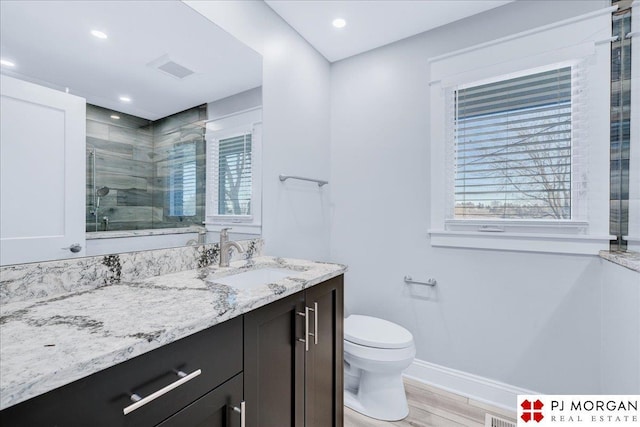 bathroom with vanity, wood-type flooring, a shower with door, and toilet