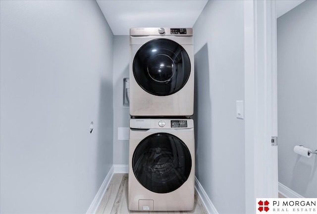 laundry room with stacked washer / dryer and hardwood / wood-style flooring