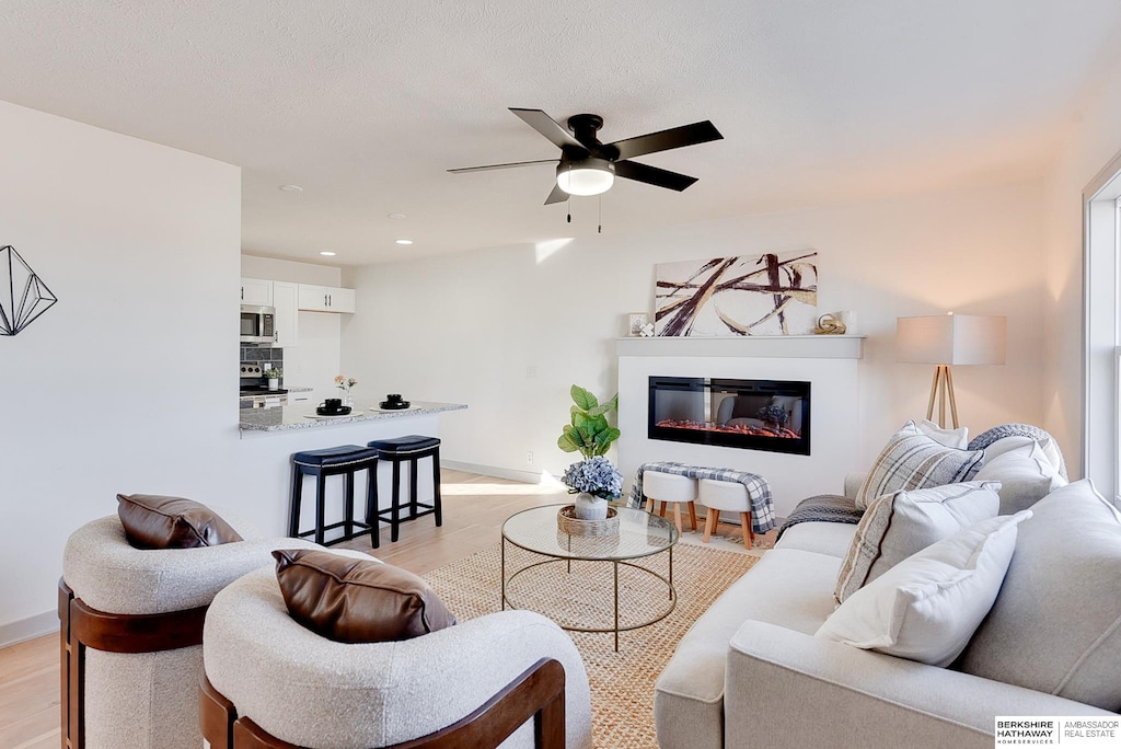 living room featuring ceiling fan and light hardwood / wood-style floors