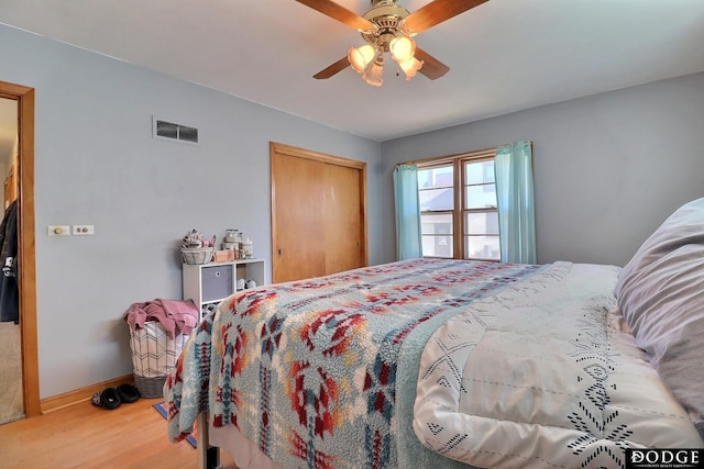 bedroom with ceiling fan, wood-type flooring, and a closet