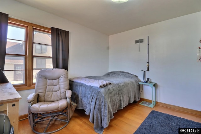 bedroom featuring multiple windows and light hardwood / wood-style floors