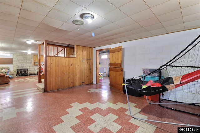 basement featuring wooden walls