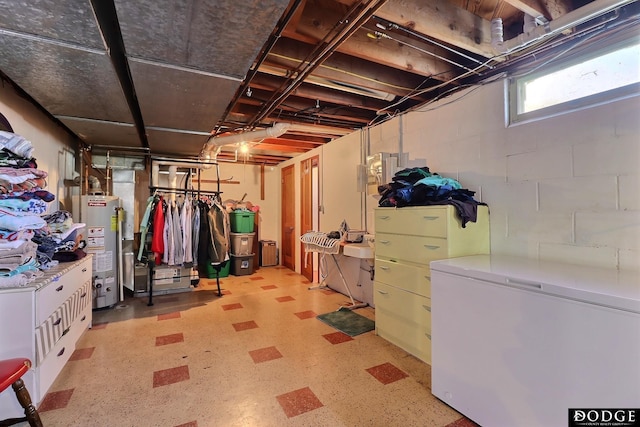 basement featuring water heater and fridge