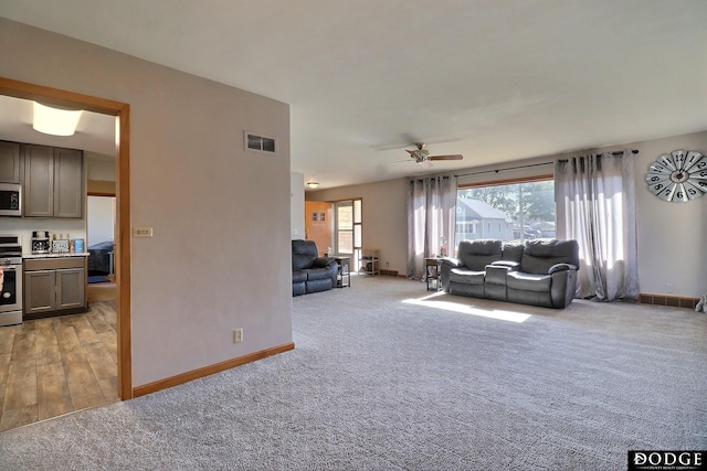 carpeted living room featuring ceiling fan