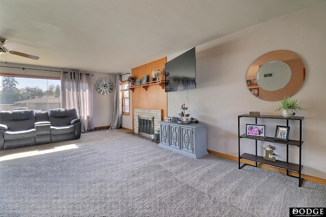 carpeted living room featuring ceiling fan and a fireplace