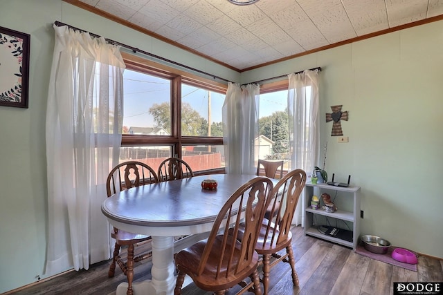 dining space featuring ornamental molding and hardwood / wood-style floors