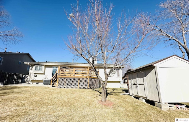 back of property featuring a wooden deck, central AC unit, and a yard