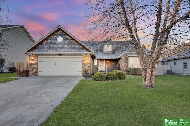 view of front of property with a garage, a yard, and central AC unit