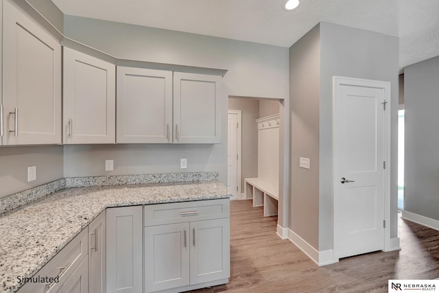 kitchen featuring light stone counters and light wood-type flooring