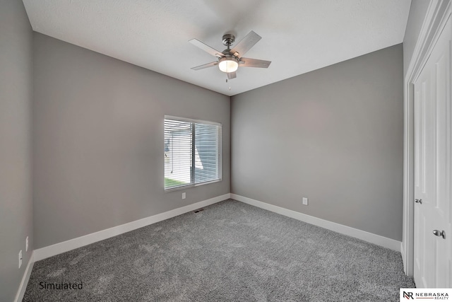 carpeted spare room with ceiling fan