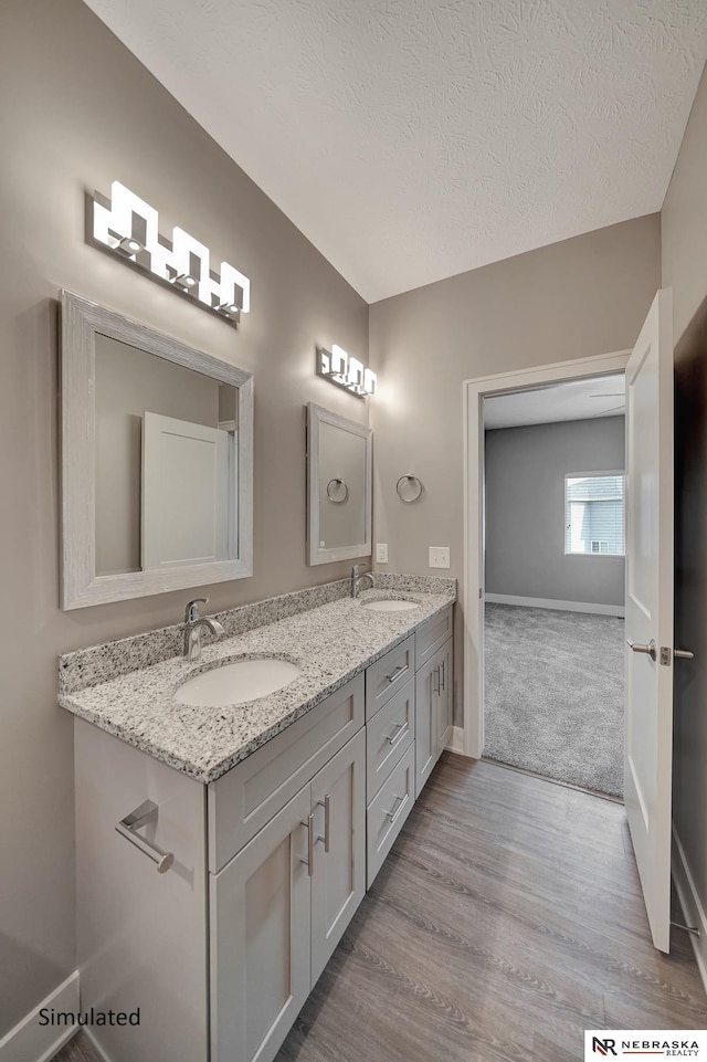 bathroom featuring vanity, hardwood / wood-style floors, and a textured ceiling