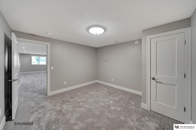 carpeted spare room with a textured ceiling