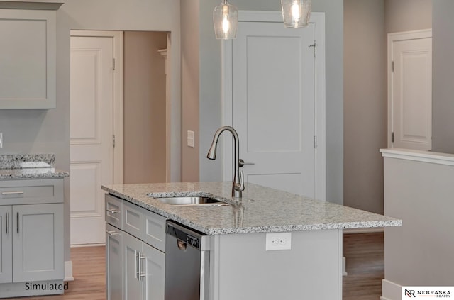 kitchen featuring sink, hanging light fixtures, dishwasher, an island with sink, and light stone countertops