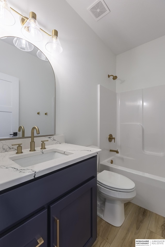 full bathroom with vanity, wood-type flooring, toilet, and shower / bath combination