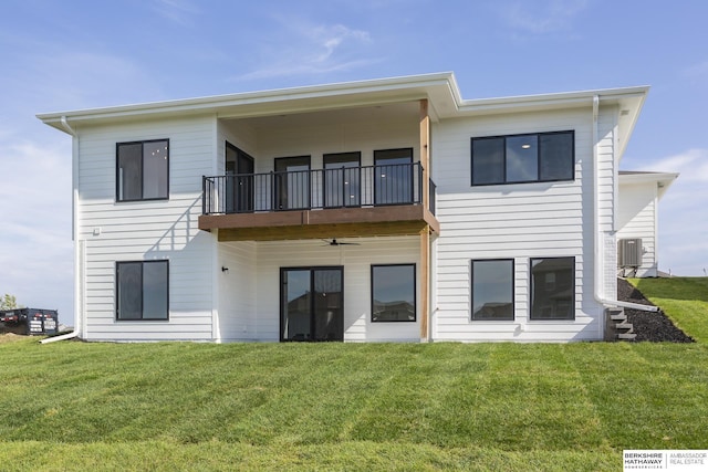 back of property with a balcony, a lawn, and central air condition unit