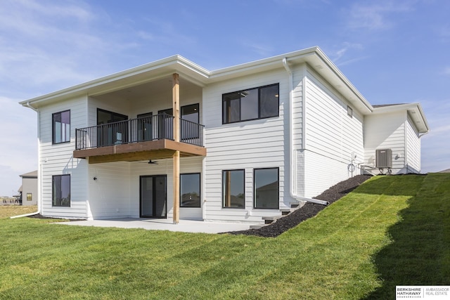 rear view of property with a balcony, a yard, a patio area, and central air condition unit