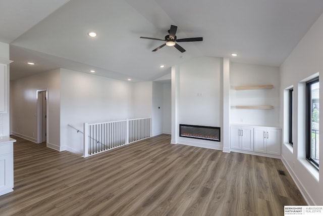 unfurnished living room with lofted ceiling, dark hardwood / wood-style flooring, and ceiling fan