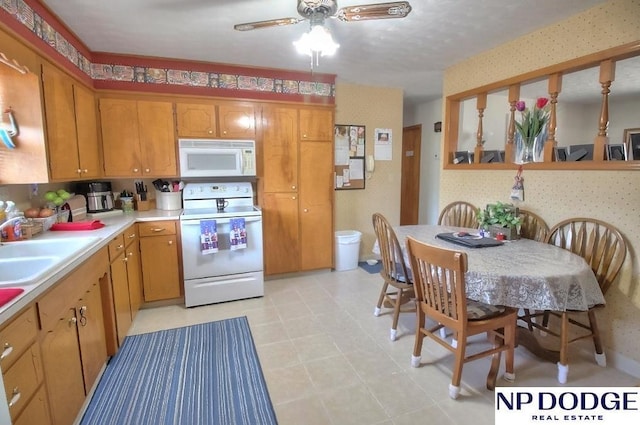 kitchen with sink, white appliances, and ceiling fan