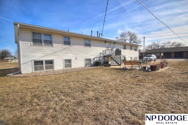 back of house featuring a yard and central air condition unit