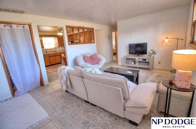 tiled living room featuring ceiling fan