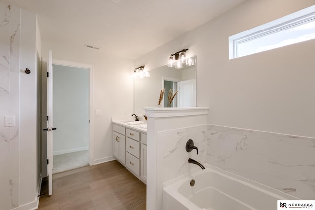 bathroom with vanity, a tub to relax in, and wood-type flooring