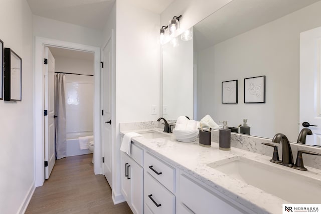 full bathroom featuring vanity, wood-type flooring, shower / tub combo, and toilet