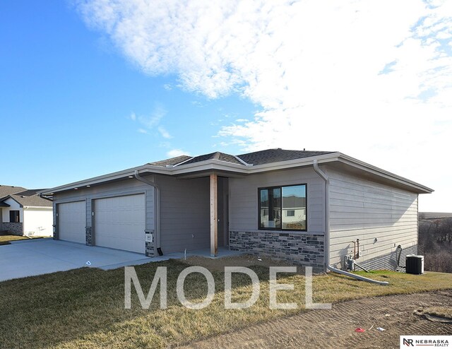 14803 Willow St, Bennington, NE 68007 - view of front facade featuring an attached garage, concrete driveway, cooling unit, stone siding, and a front yard
